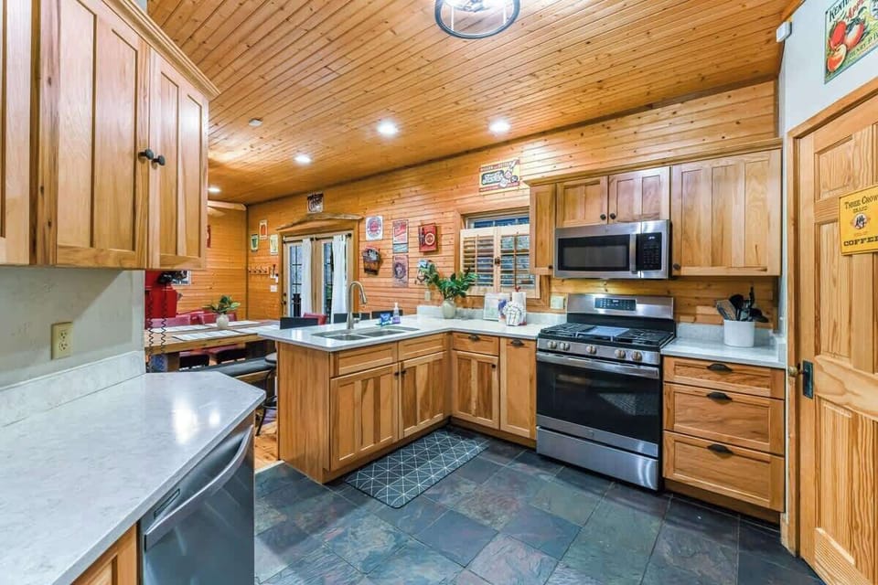Rustic kitchen with stainless steel appliances and ample wooden cabinetry.