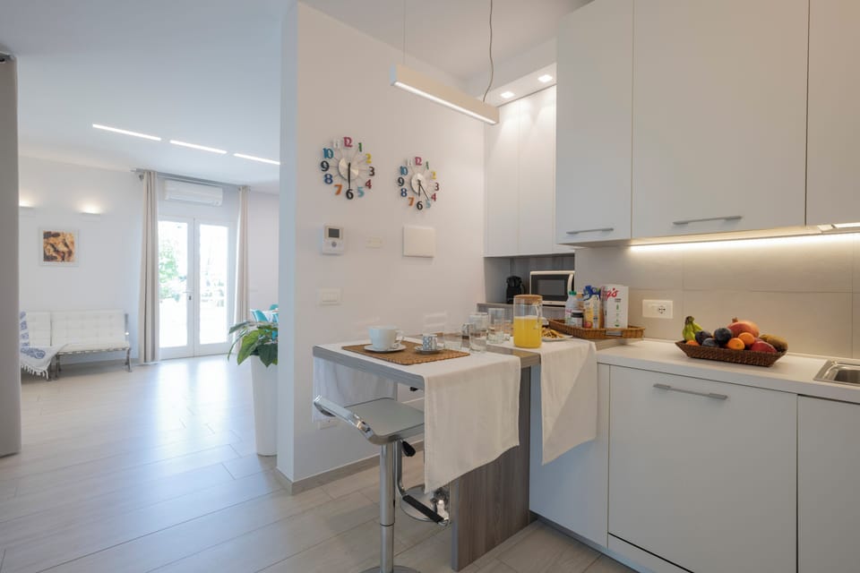 Villa Kenja _ Cucina con vista su Soggiorno _ Accesso su Veranda e Giardino