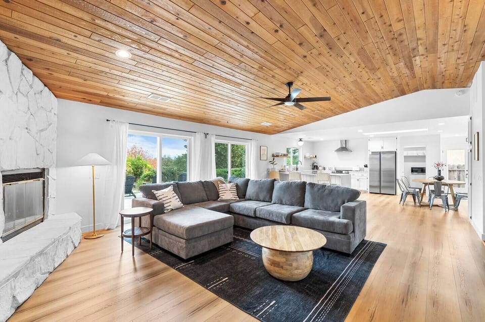Relax in the airy living room with vaulted cedar ceilings and natural light pouring in. The open layout keeps the kitchen and living room connected, so you can cook, unwind, and stay close to your group.