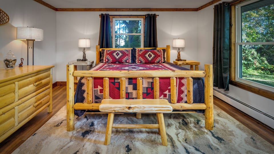 Master king bed sweetly blends native themes with rustic log furniture.
