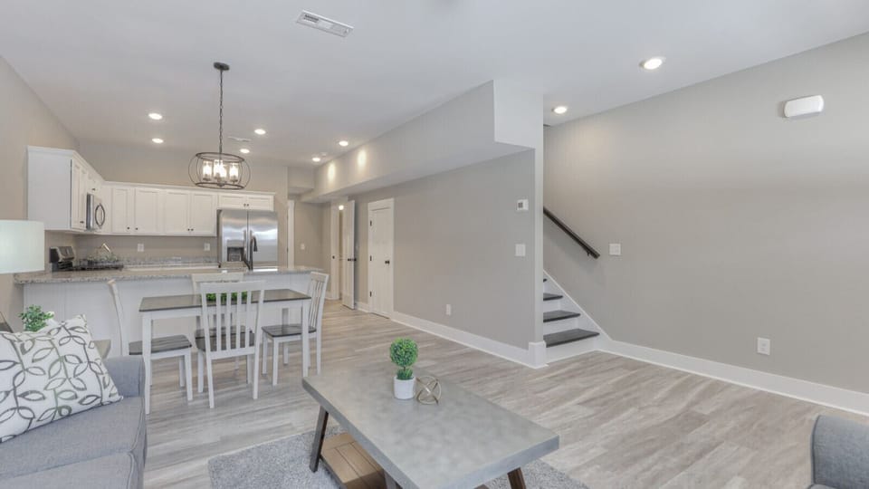 Spacious open floor plan featuring a sleek kitchen, comfortable dining space, and inviting living area, designed for family and group enjoyment.