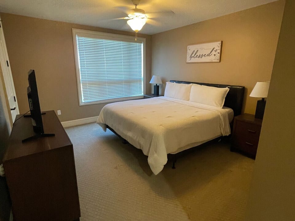 Relax in your bright and elegant bedroom at The Gateway Village, featuring a large bed and window view. Everything you need for a comfortable long-term stay in Murfreesboro.