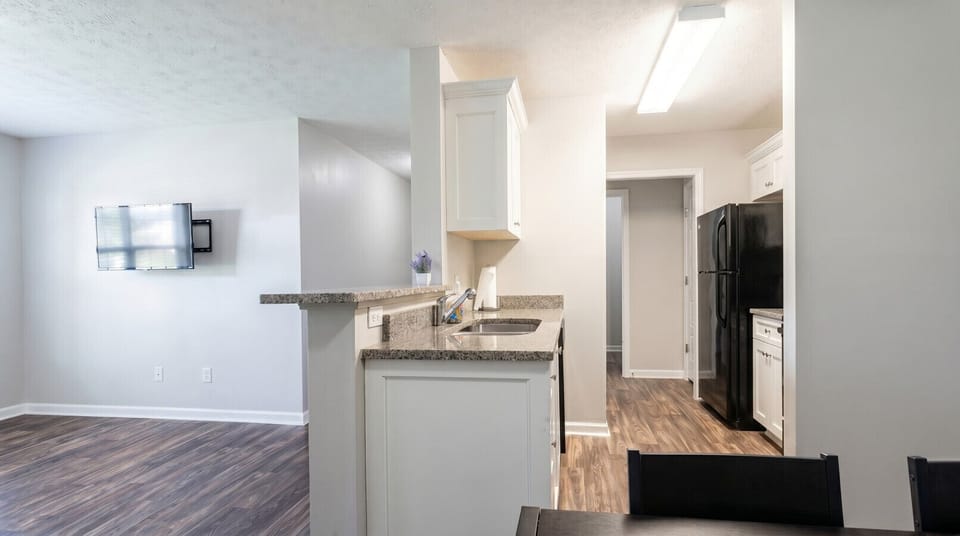 Fully equipped kitchen with full-size refrigerator, electric stove, microwave, and granite countertops. Furnished apartment for rent in Columbus, GA — ideal for extended stays, military relocation, and traveling professionals near Fort Benning.