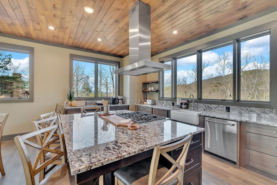 Large custom kitchen island with 36" gas cooktop and 42" hood.