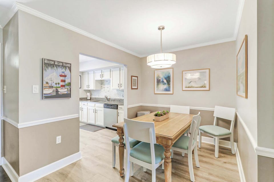 Gather the whole group around the farmhouse dining table, which seats six comfortably. A drum pendant light and Hilton Head Island art make every meal feel like a special occasion.