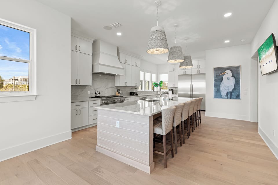 Your spacious chef's kitchen features pristine white cabinetry, gleaming countertops, and a grand island where culinary memories await creation together.