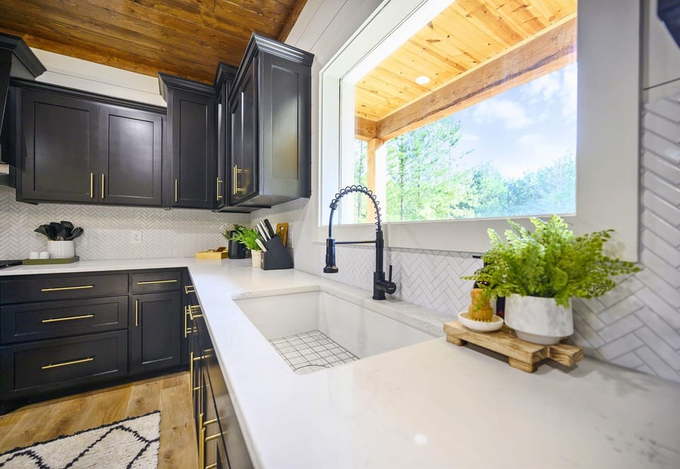 The bright kitchen window and modern counters create the ideal space for prepping meals while enjoying the view outside.