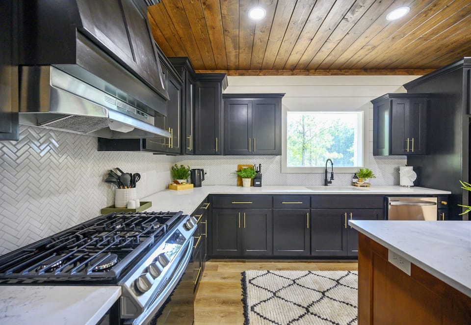Another view of the kitchen reveals its clean lines, warm wood accents, and natural light streaming through the window.