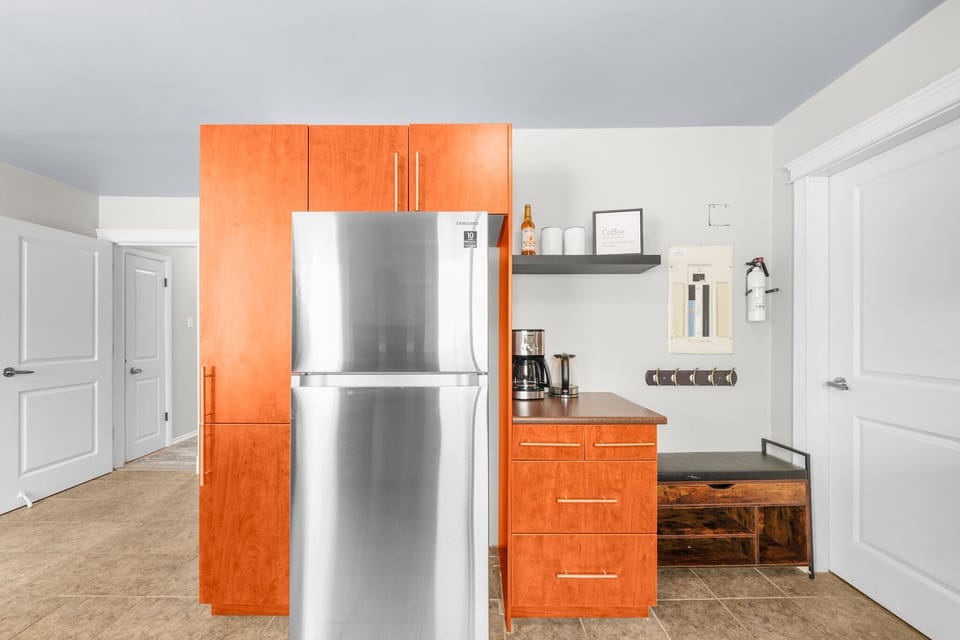 Modern kitchen with stainless steel fridge, coffee maker.