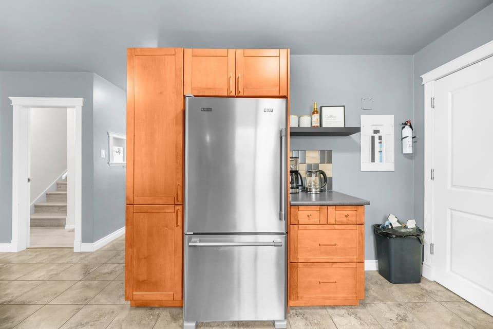 Modern kitchen with stainless steel fridge, coffee maker.