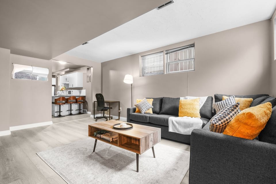Stylish living room with modern sofas, large TV, and plenty of natural light.
