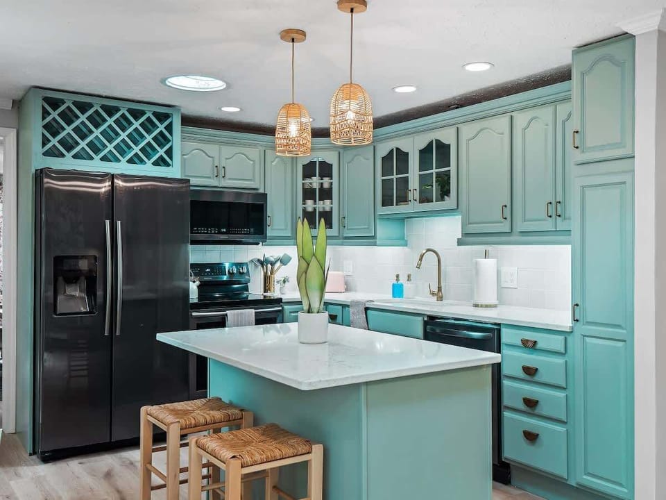 Airy kitchen w/ island, pendant lighting & open flow into living areas