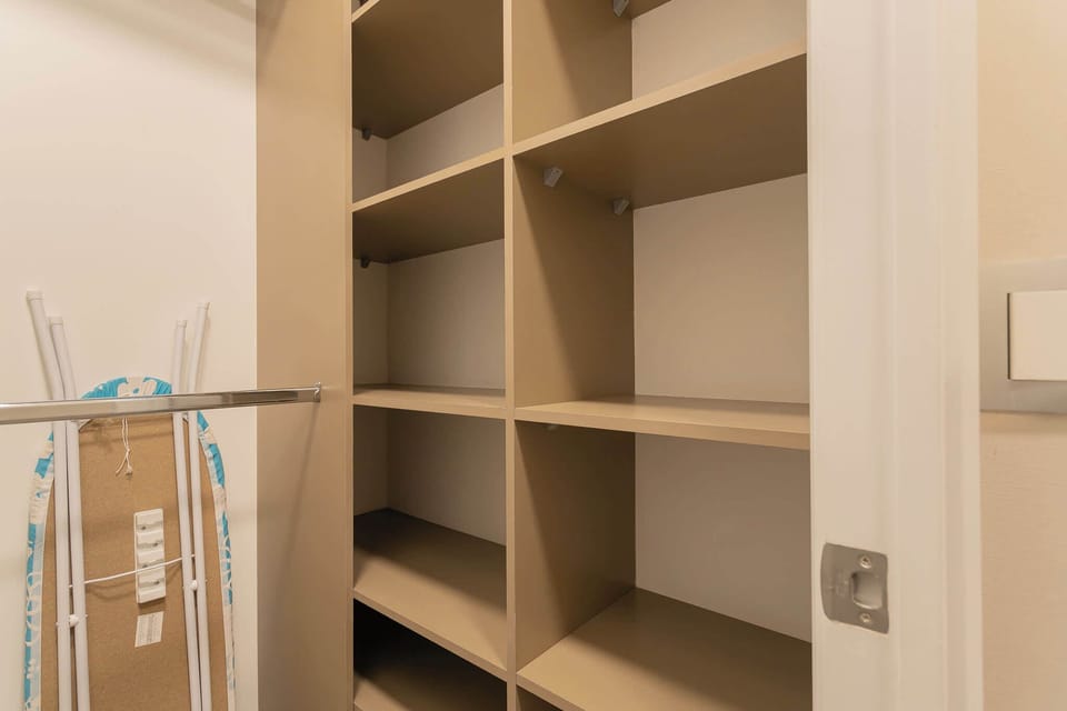 Spacious closet with ample shelving and ironing amenities for your convenience.