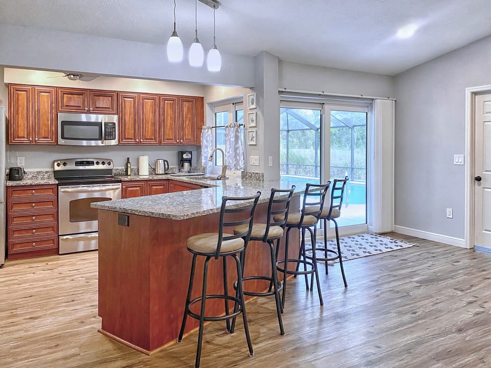 Kitchen 1 - 4 bar chairs, sliding door to the pool