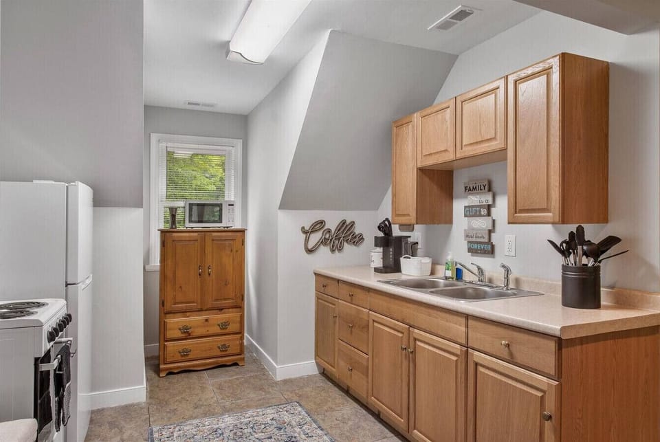 Kitchen on upper level with stove, oven, storage space, microwave, fridge, freezer and Keurig coffee maker.