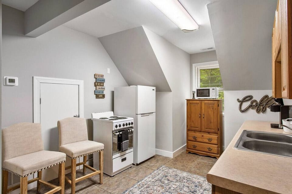 Kitchen on upper level with stove, oven, storage space, microwave, fridge, freezer and Keurig coffee maker.