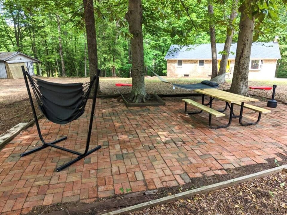 This is the brick patio area with a picnic table, cornhole and two hammocks, as well as a smoker`s pole (please dispose of used butts properly); this is the only shared space between the two homes on the property.