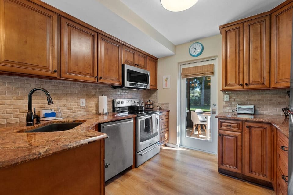 Warm wood and beautiful countertops make this kitchen a dream to cook in.