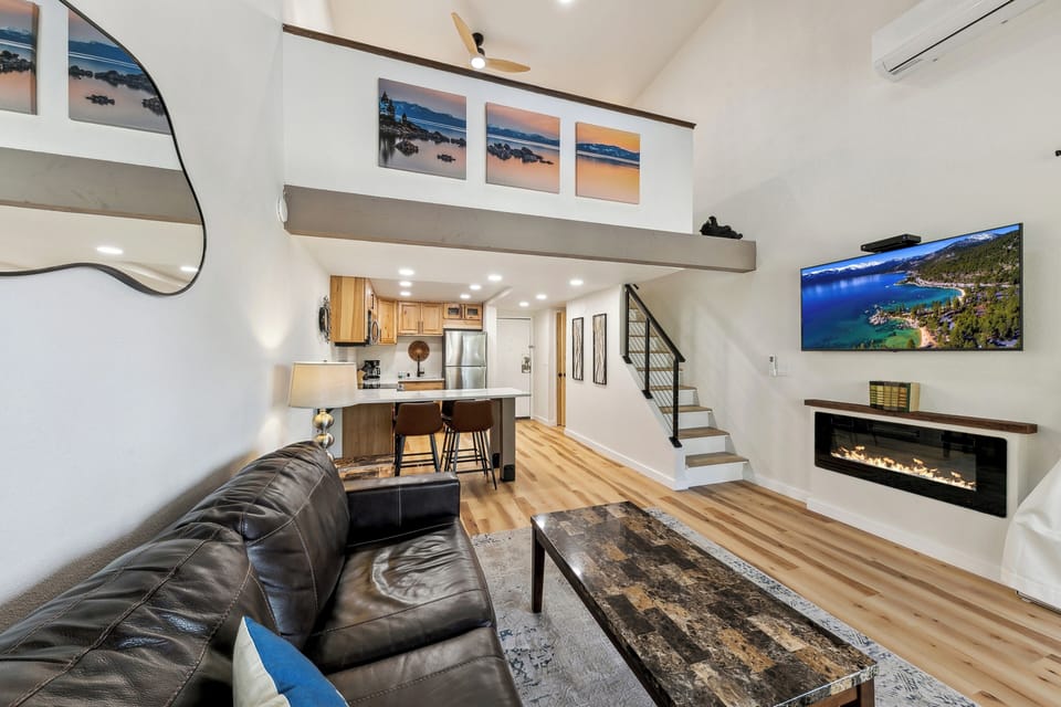 Relax in your stylish open-concept loft with soaring ceilings, modern fireplace, and leather seating that flows into a fully-equipped kitchen.