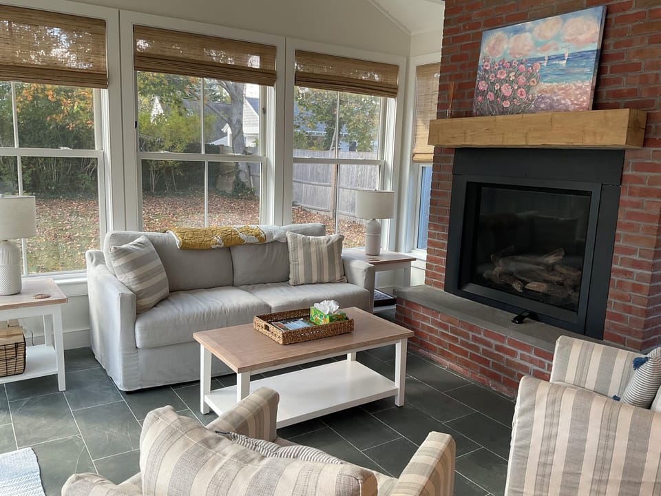 Sun room with gas fireplace and French doors leading out onto the patio area
