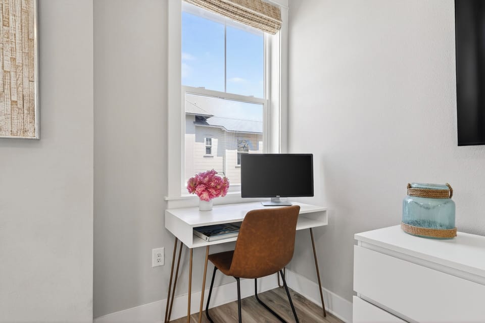 The primary bedroom features a king bed, TV, desk and an ensuite bathroom.