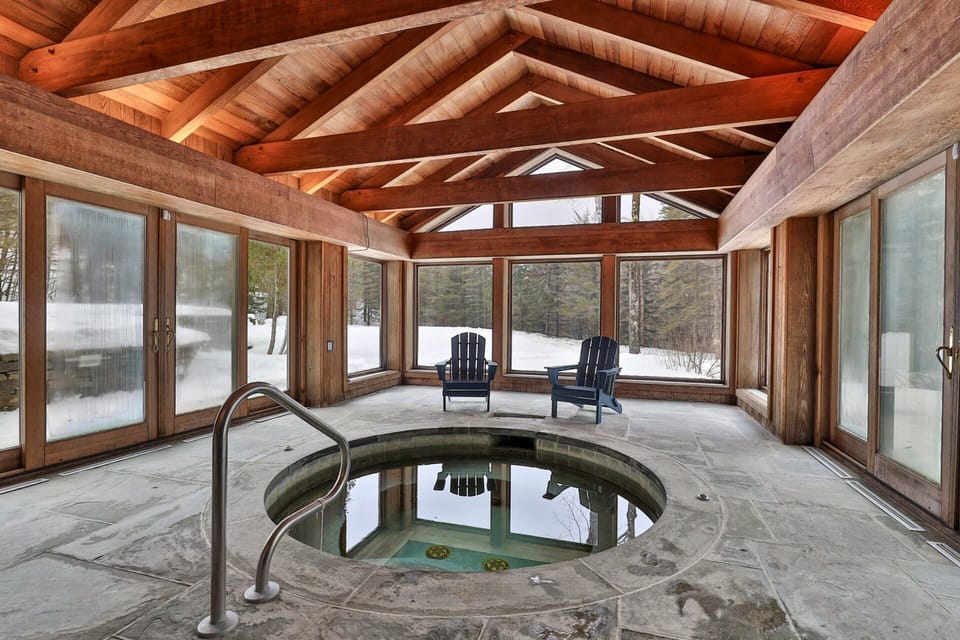 Settle into the indoor hot tub in a timber-framed room wrapped in windows.