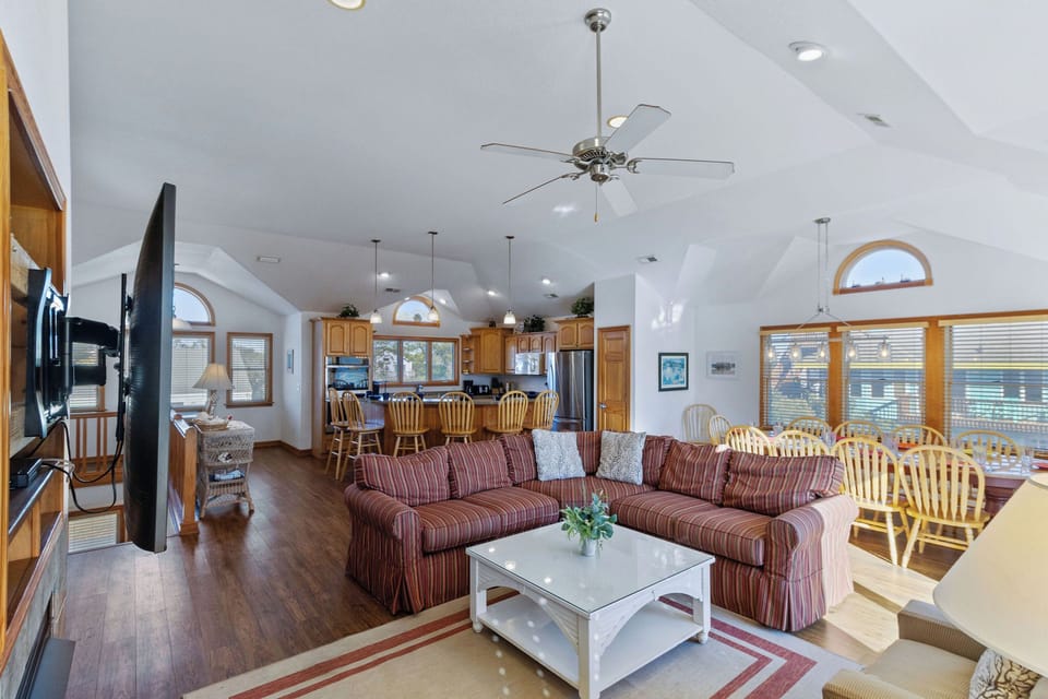 Living Room - Large windows with natural light amplify the high ceilings in the home's open living spaces.