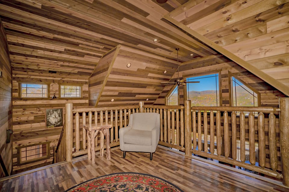 Cozy cabin living room with fireplace and rustic wooden charm.
