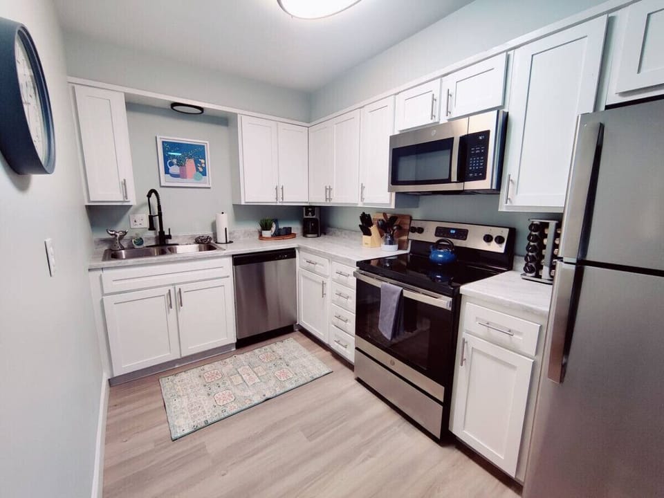 Transform your cooking experience with this stunning kitchen adorned with sleek stainless steel appliances and elegant white cabinets.