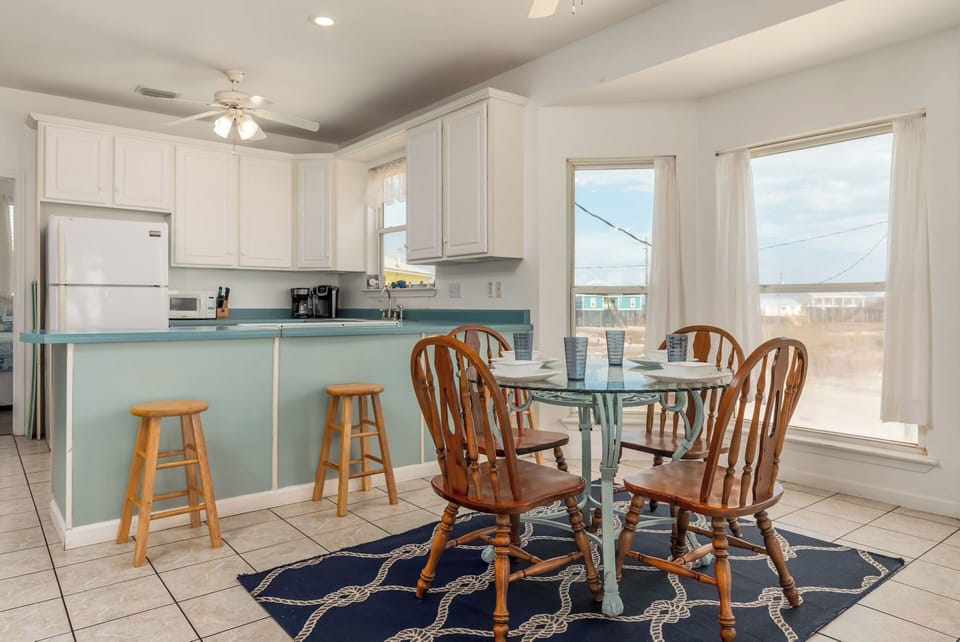 Gather around your coastal kitchen with its charming breakfast bar and sunny dining space—perfect for morning coffee.