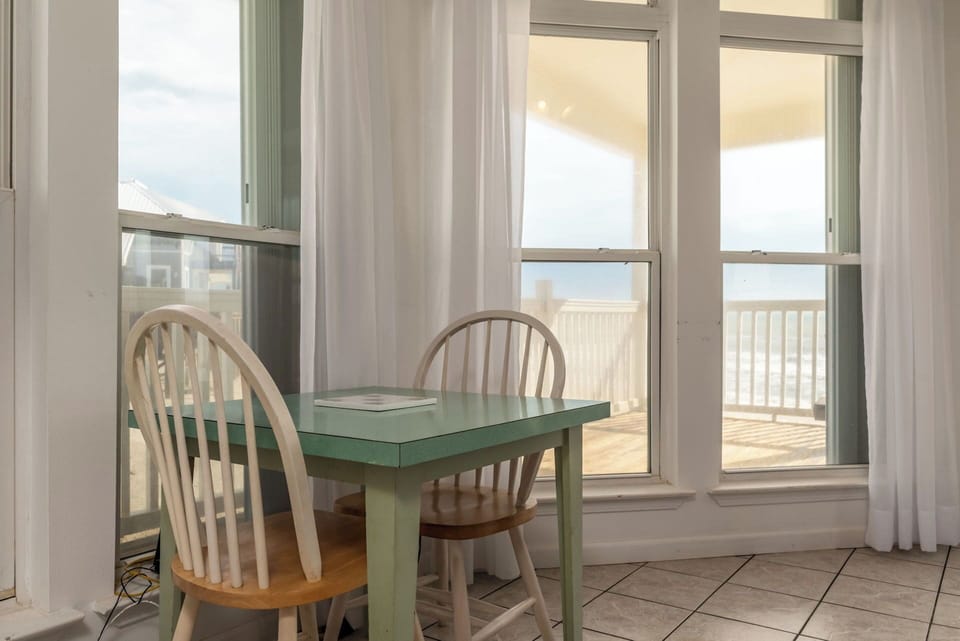 Enjoy meals with an ocean view at your charming dining table, where sunlight streams through large windows.