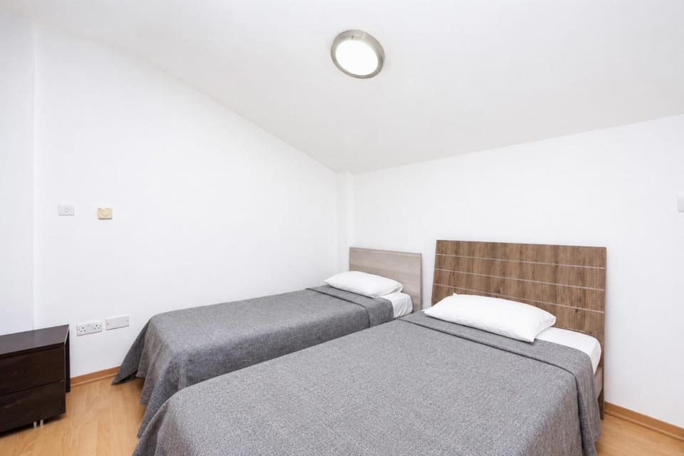 An interior view of a third bedroom, located in a charming loft or attic space with unique architectural angles.
