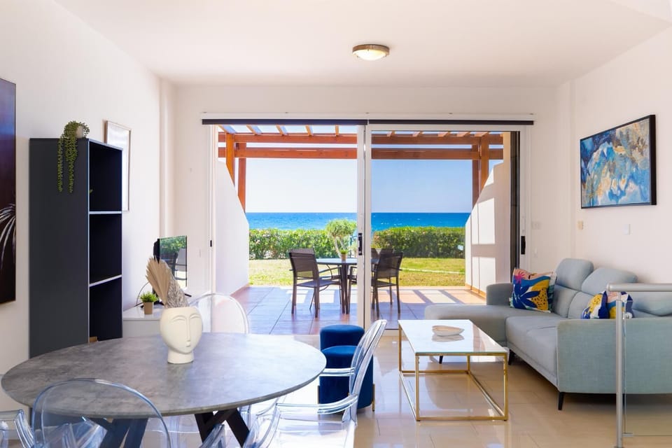 A view from the dining space looking out toward the patio, capturing the full depth of the bright ground floor layout and its expansive coastal backdrop.