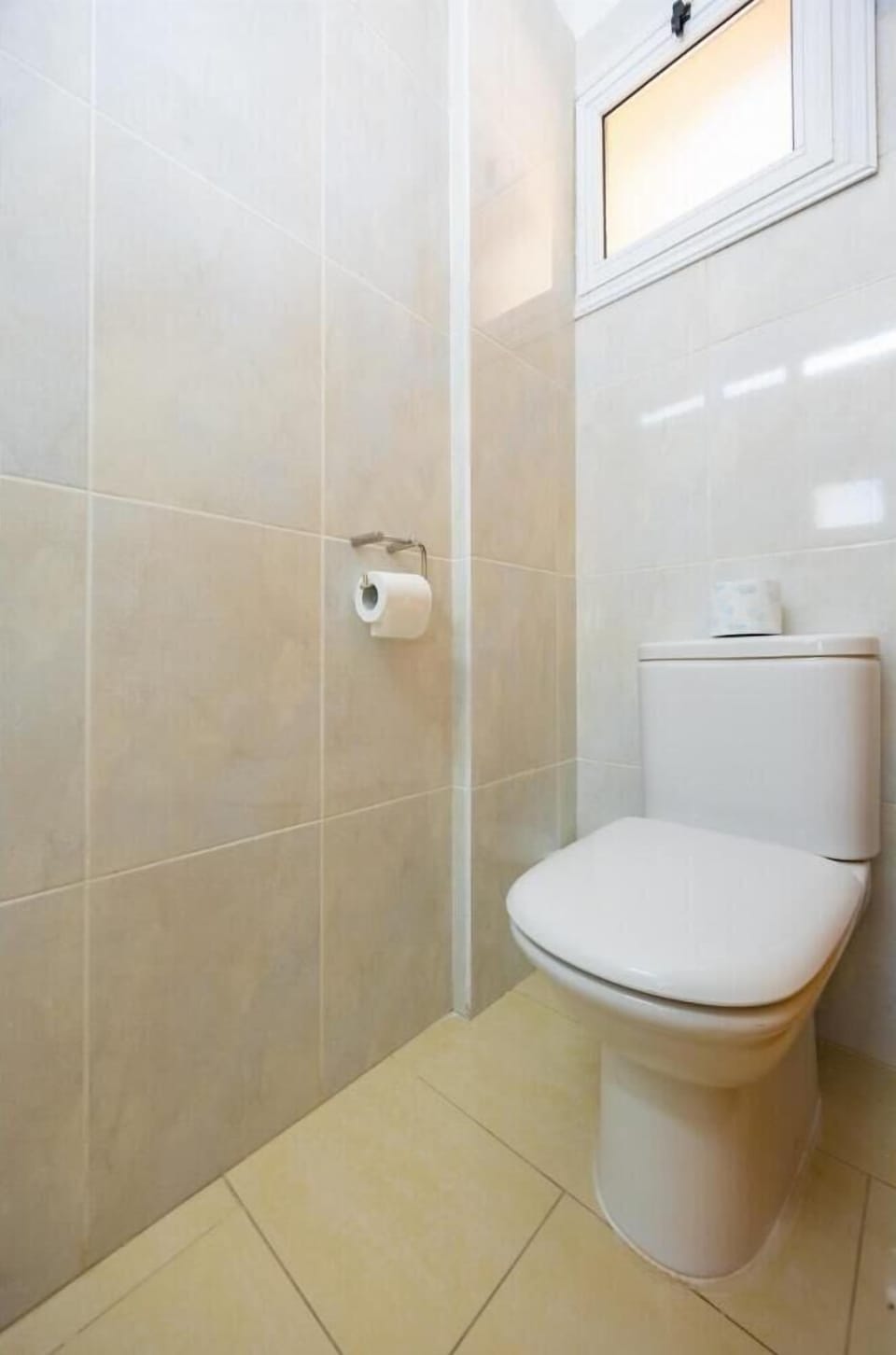 An interior view of a compact restroom or guest toilet within the property, showcasing a clean and simple design.