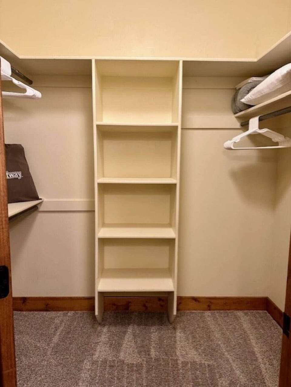 Master bedroom walk in closet; hangers and extra blankets, pillows