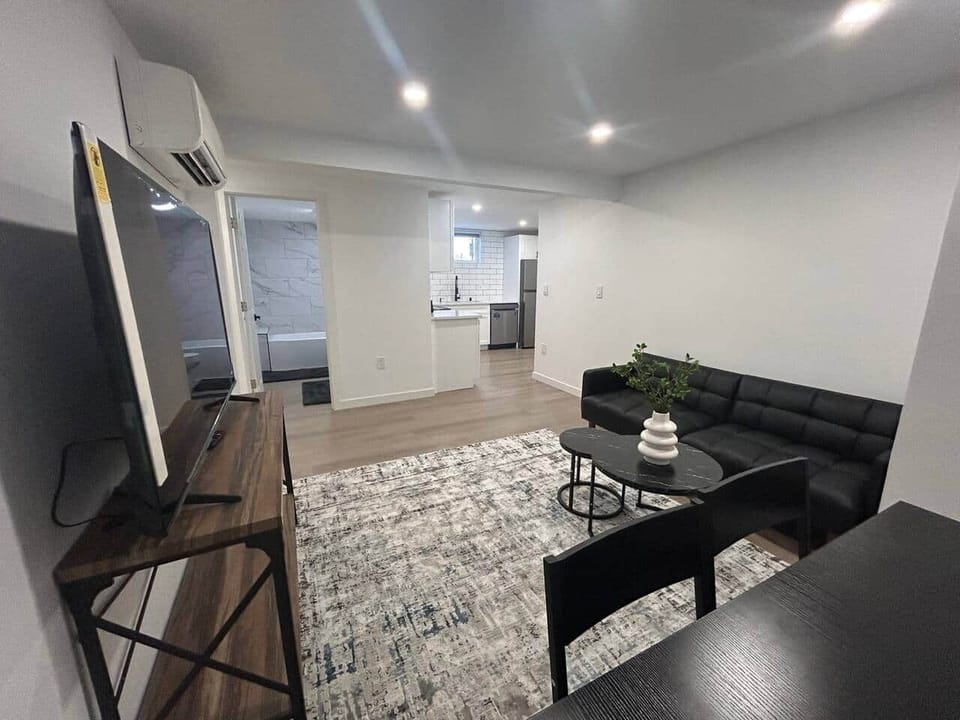 Spacious living room with smart 58 inches TV and sofa bed.