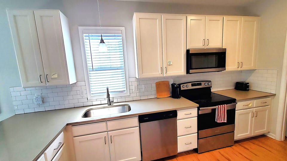 Full kitchen with Fridge, dishwasher, Coffee Maker, Toaster, utensils, cutlery. 