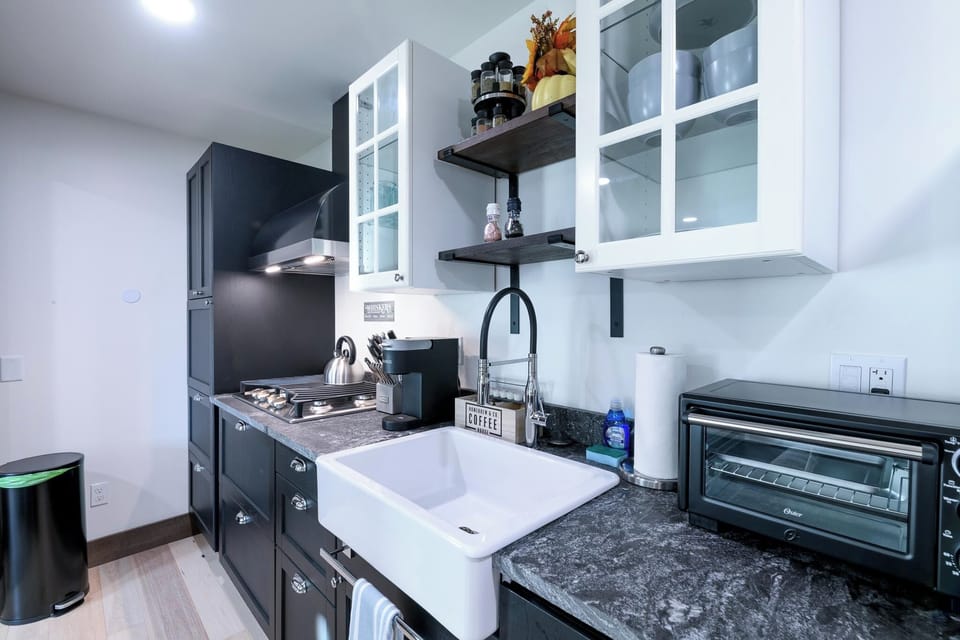 Fully equipped kitchen with gas stove, toaster oven, and all cooking essentials.