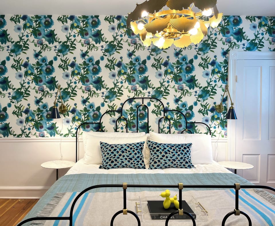 Suite 1: Private entrance with semi-private porch or additional optional entry through hallway, King Anthropologie bed, 50" Smart TV, porcelain tile bath, and option to adjoin with Suite 2. 