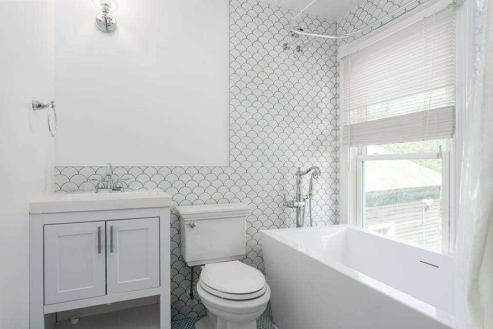 Suite 6: Queen bed, 50" Smart TV, porcelain tile bath with soaking tub, and table with 2 chairs for meals or WFH.
