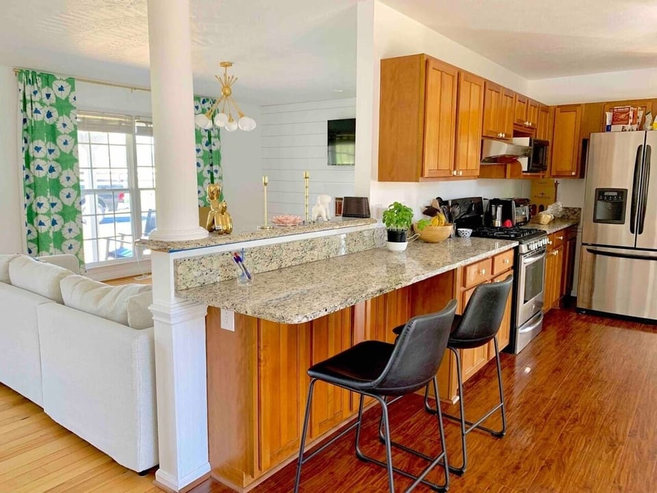 The kitchen spans both sides of this room and has lots of counter space for preparing cocktails or your next meal. Move those 2 black chairs and you have a perfect spot for a mimosa bar or buffet!