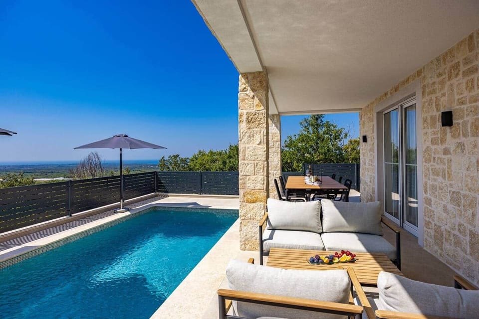 Poolterrasse mit Meerblick, Sonnenschirm und direktem Zugang zum Wohnbereich