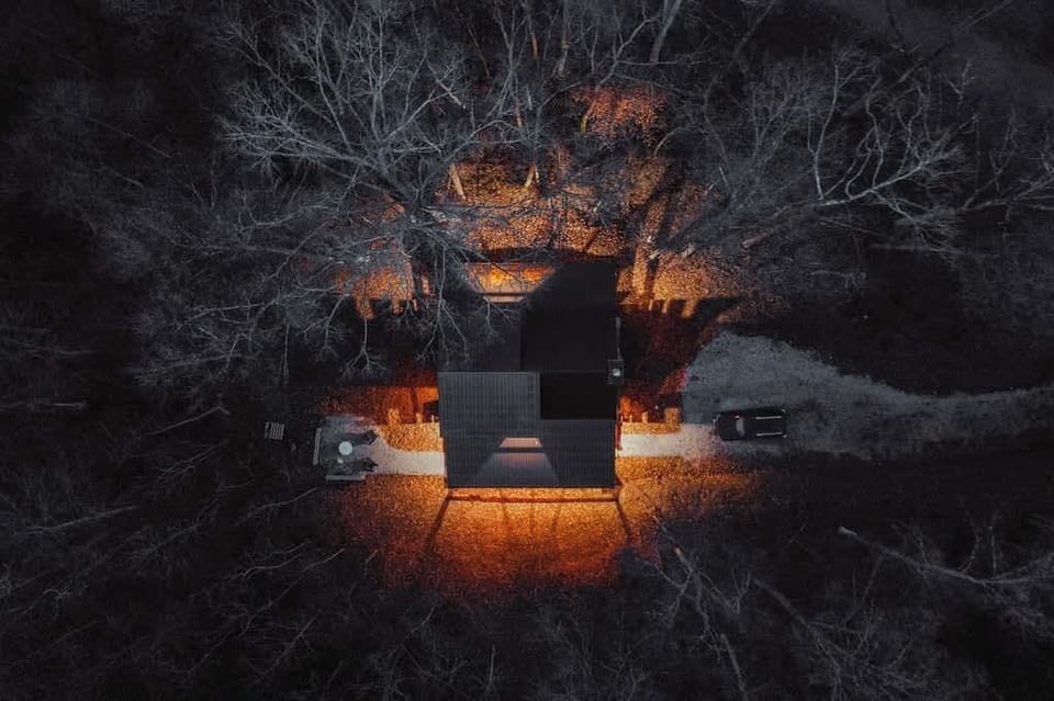 Charming Retreat: Nestled among trees, illuminating nights with warm, inviting light!