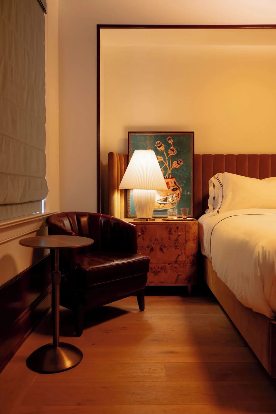 Unwind in a warmly lit bedroom with cozy reading nook.
