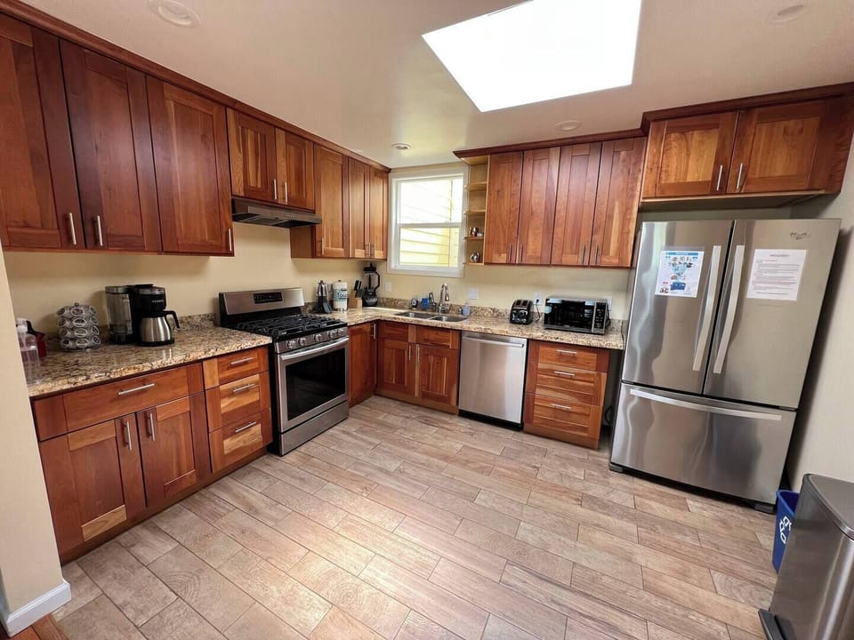 Kitchen features a stove/oven, large sink, refrigerator, and other appliances.