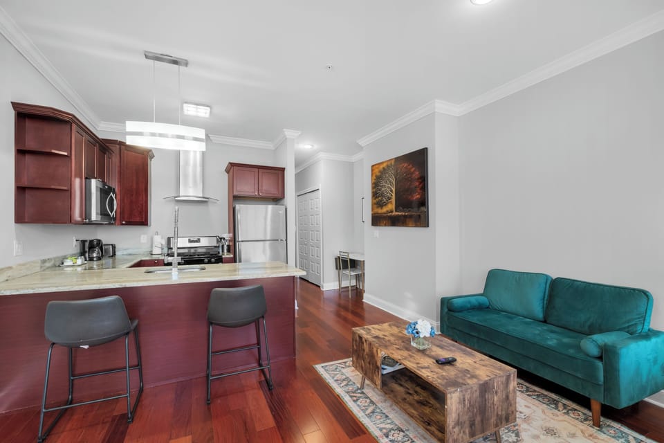 Living area corner with teal sofa, throw pillows, and decorative accents creating inviting space.