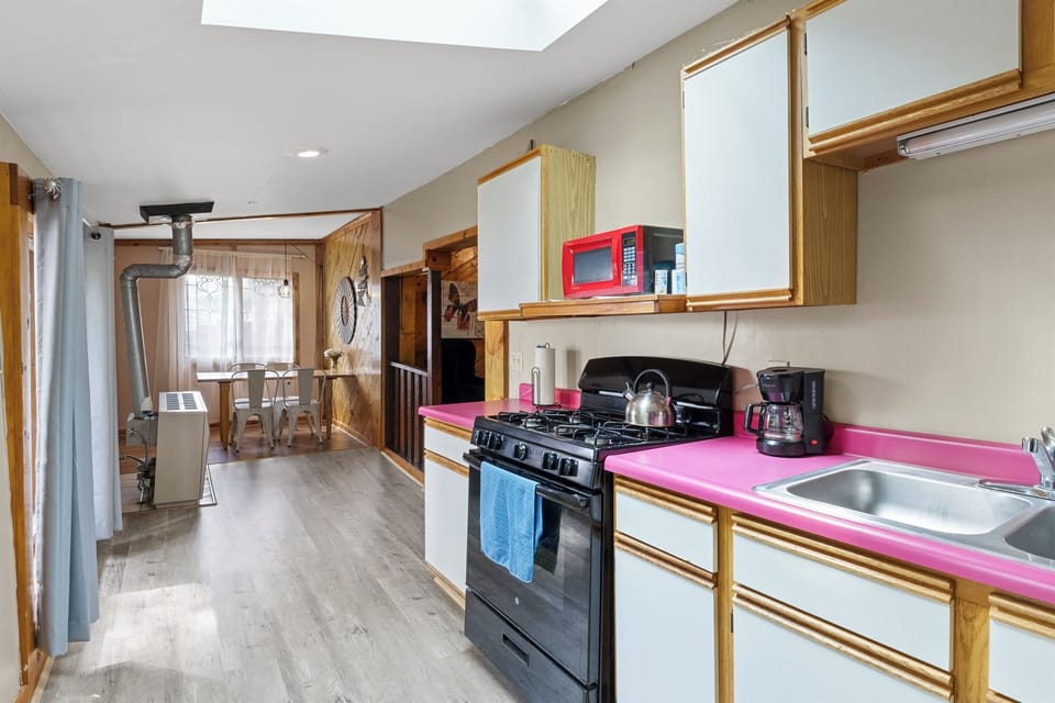 Kitchen - The kitchen offers a bright and functional space, complete with modern appliances and a long countertop. Perfect for preparing meals while enjoying the view through the large window.
