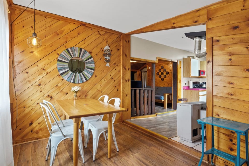 Dining Area - Enjoy a cozy meal in this charming wood-paneled dining area, offering natural light and a warm, inviting atmosphere. The perfect spot to gather for breakfast before exploring the lakefront or nearby hiking trails.