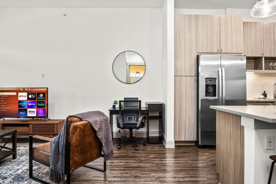 Bright and airy living room with plush seating, a large TV, and tasteful decor, creating the perfect space for relaxation and entertainment.