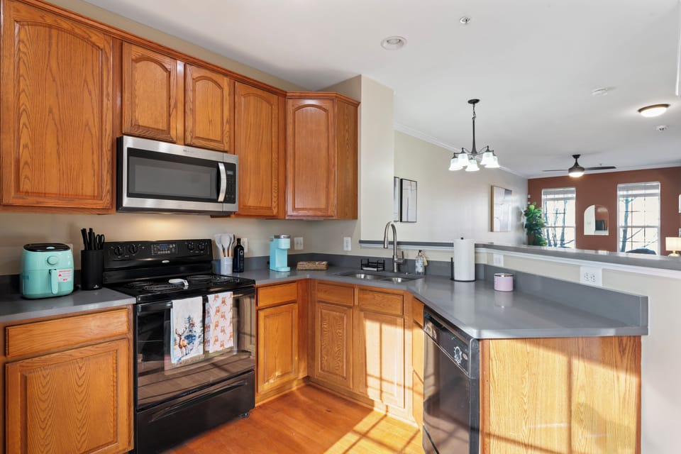 Fully stocked kitchen with appliances, toaster, blender, and utensils, pots/pans